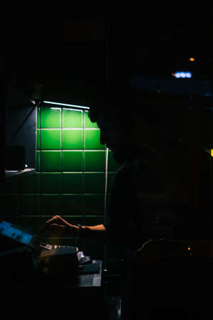 Young man asian bistro worker using computer to accepts online order for delivery or checks the...
