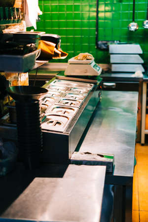 Kitchen table with professional equipment in a public cafe.の写真素材