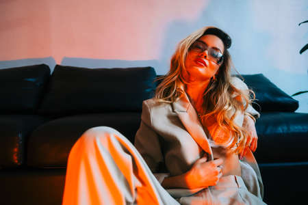 Young caucasian stylish woman fashion model with perfect body wearing in a suit and bra lingerie.