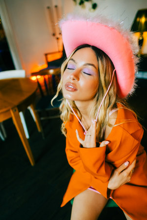 Portrait of attractive caucasian woman fashion model with blonde hair in pink cowboys hat , posingの写真素材