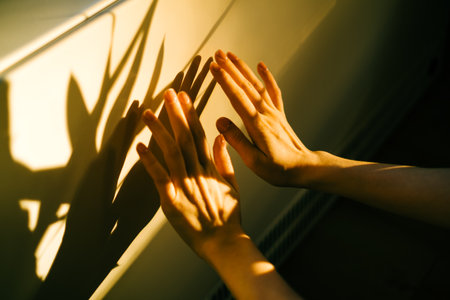 Woman warms up hands over heater. Concept of the need for good central heating.の写真素材