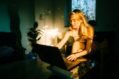 Portrait of young caucasian woman college student studying with laptop, distantly preparing for test exam, writing essay doing homework at home.の写真素材