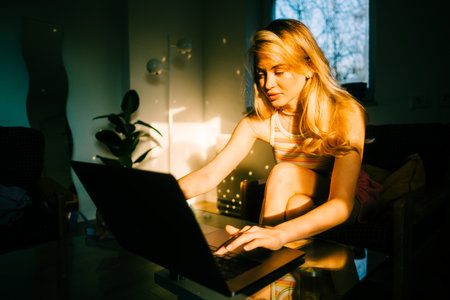 Portrait of young caucasian woman college student studying with laptop, distantly preparing for test exam, writing essay doing homework at home.の写真素材
