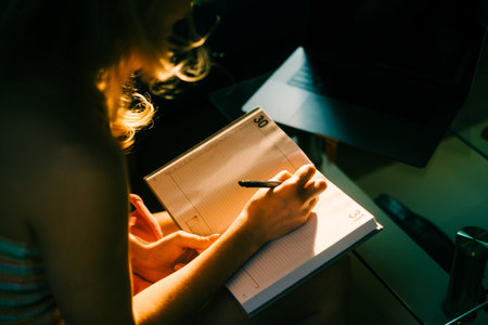 Caucasian woman making notes at home office.の写真素材