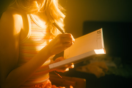 Caucasian woman making notes at home office.の写真素材