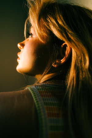 Portrait of attractive caucasian woman with blonde hair posing in sunset light indoor.の写真素材