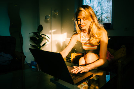 Portrait of young caucasian woman college student studying with laptop, distantly preparing for test exam, writing essay doing homework at home.の写真素材