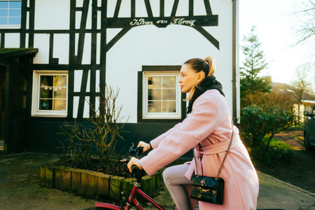 Young attractive caucasian woman ride on bicycle on city street in Europe.の写真素材