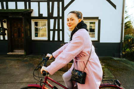 Young attractive caucasian woman ride on bicycle on city street in Europe.の写真素材