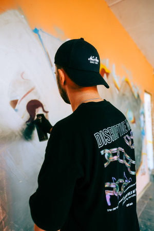 Young caucasian man graffiti artist drawing on a wall.のeditorial素材