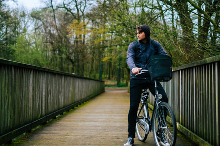 Young caucasian man ride on bicycle in the park.の写真素材