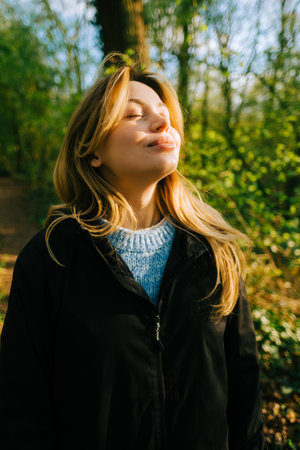 Attractive caucasian woman breathe fresh air , enjoying springtime on a sunset in natural parklandの写真素材