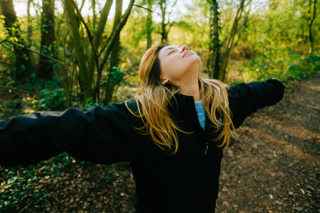 Attractive caucasian woman breathe fresh air , enjoying springtime on a sunset in natural parklandの写真素材