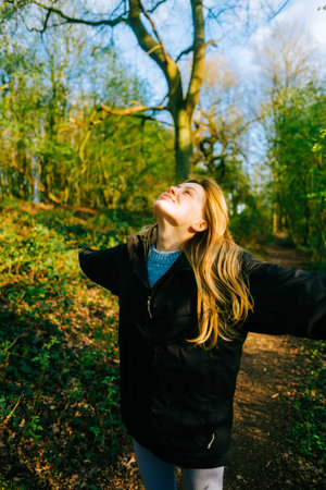 Attractive caucasian woman breathe fresh air , enjoying springtime on a sunset in natural parklandの写真素材