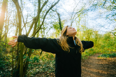 Attractive caucasian woman breathe fresh air , enjoying springtime on a sunset in natural parklandの写真素材
