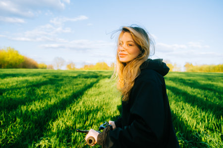 Portrait of young caucasian attractive woman with bicycle at the field in countryside .の写真素材