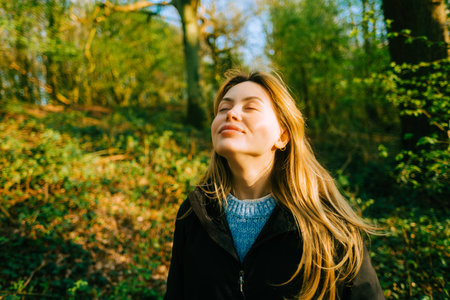 Attractive caucasian woman breathe fresh air , enjoying springtime on a sunset in natural parklandの写真素材