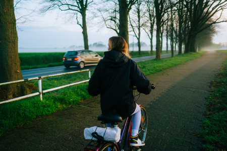 Woman cyclist riding on bicycle in the park in springtime.の写真素材