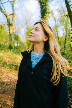 Attractive caucasian woman breathe fresh air , enjoying springtime on a sunset in natural parklandの写真素材