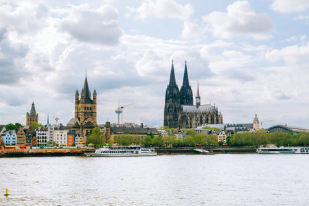 Great St. Martin Church and Kolner Dom with old colorful houses of Cologne and cloudy sky hdr background.の写真素材