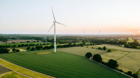 Large wind turbines with blades in field aerial view and sunset blue sky. alternative energyの写真素材