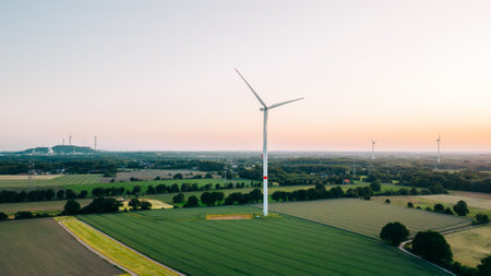 Large wind turbines with blades in field aerial view and sunset blue sky. alternative energyの写真素材