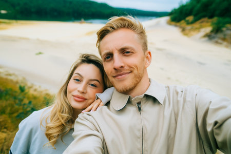 Young couple taking selfie photo in travel trip near forest lake.の写真素材