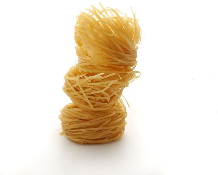 Dry egg pasta pile isolated on white.の写真素材