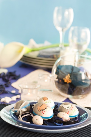 Easter table setting in blue and white tones with candles and flower.の写真素材