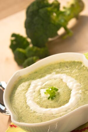 Rich vegetable broccoli soup with cream garnishの写真素材