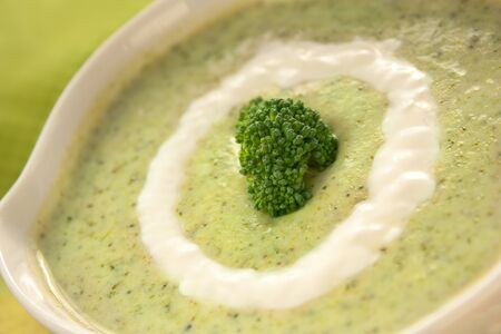 Rich vegetable broccoli soup with cream garnishの写真素材