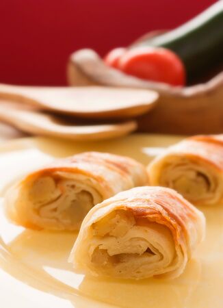 Potato filo pastry with vegetables and cutlery in the back.の写真素材