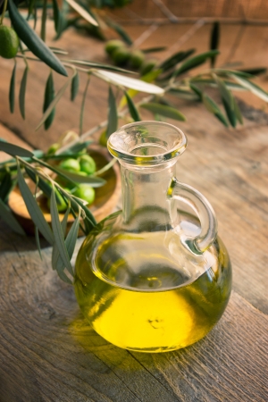 Extra virgin healthy Olive oil with fresh olives on rustic wooden backgroundの写真素材