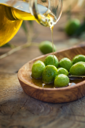 Extra virgin healthy Olive oil with fresh olives on rustic wooden backgroundの写真素材