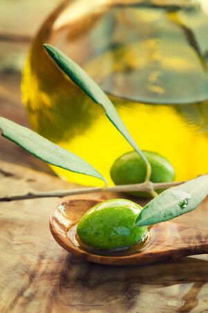 Extra virgin healthy Olive oil with fresh olives on rustic wooden backgroundの写真素材