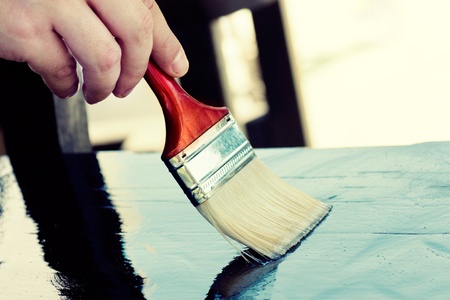 Carpenter is painting wooden furniture for protectionの写真素材