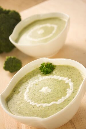 Rich vegetable broccoli soup with cream garnishの写真素材