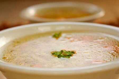 Clear vegetable soup close up. Shallow depth of field.の写真素材