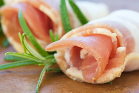 Slices of rolled bacon with rosemaryの写真素材