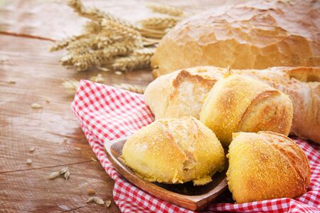 Freshly baked bread variety on wooden backgroundの写真素材