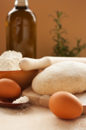 Ball of homemade dough with flour and olive oil in the back.の写真素材