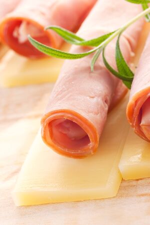 Slices of ham and cheese with rosemaryの写真素材