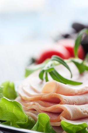 Slices of ham on lettuce with rosemary.の写真素材