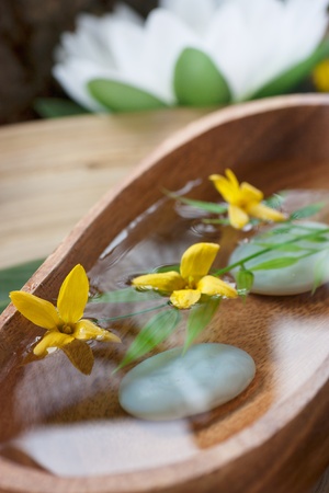 Spa setting with water for treatment and flowers.の写真素材