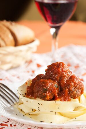 Pasta with tower aranged meatballs in tomato sauceの写真素材