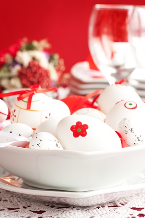 Easter table setting in red tones with candles and flower.の写真素材