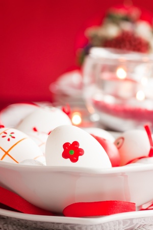 Easter table setting in red tones with candles and flower.の写真素材