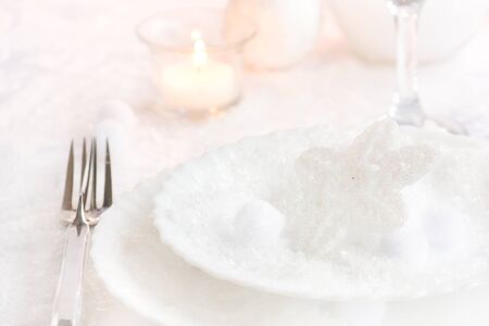 Christmas table setting. Fork and knife in elegant holiday setting with snow and white ornamentsの写真素材
