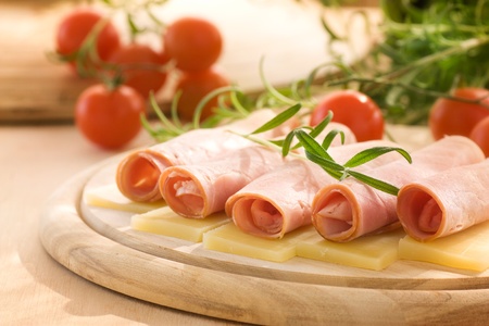 Slices of ham and cheese with rosemaryの写真素材