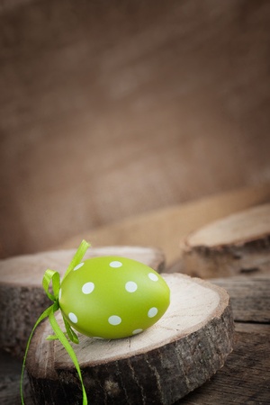 Easter holiday background with easter egg in natural wood settingの写真素材